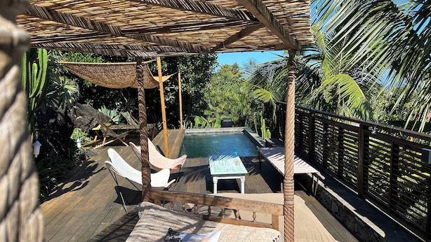 A wooden deck with a pool, lounge chairs, and a pergola. - Louisette à la Rivière  (La Rivière St Louis)