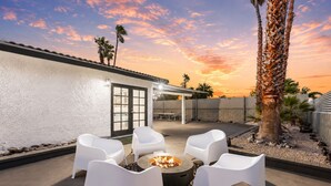 An outdoor patio with white chairs, a fire pit, and a view of the sunset. - 30% Off September, Great 4 Families -Pool, Jacuzzi (Palm Springs)