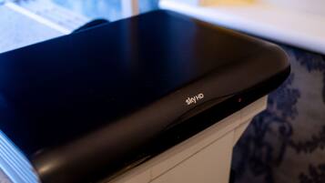 A black SkyHD device on a white surface.