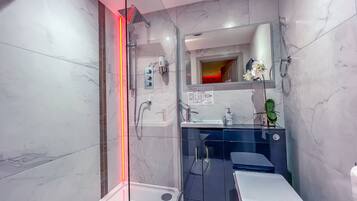 A modern bathroom with a glass-enclosed shower, a vanity with a sink, and a toilet.