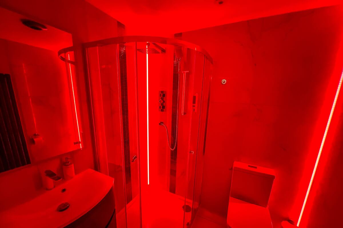 A modern bathroom with a glass-enclosed shower, a sink, and a toilet.