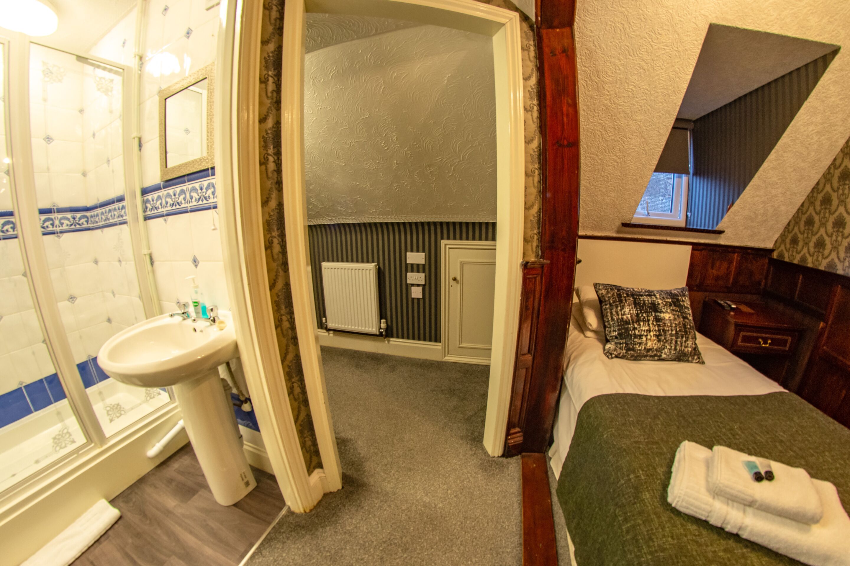 Un dormitorio con una cama, una mesita de noche y una ventana.