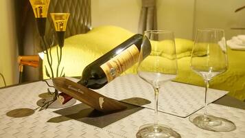 A table with a bottle of wine, two glasses, and a decorative candle holder.