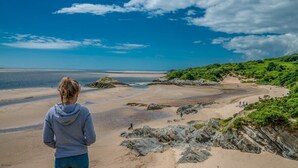 A beach with rocky outcrops and a clear view of the sea.