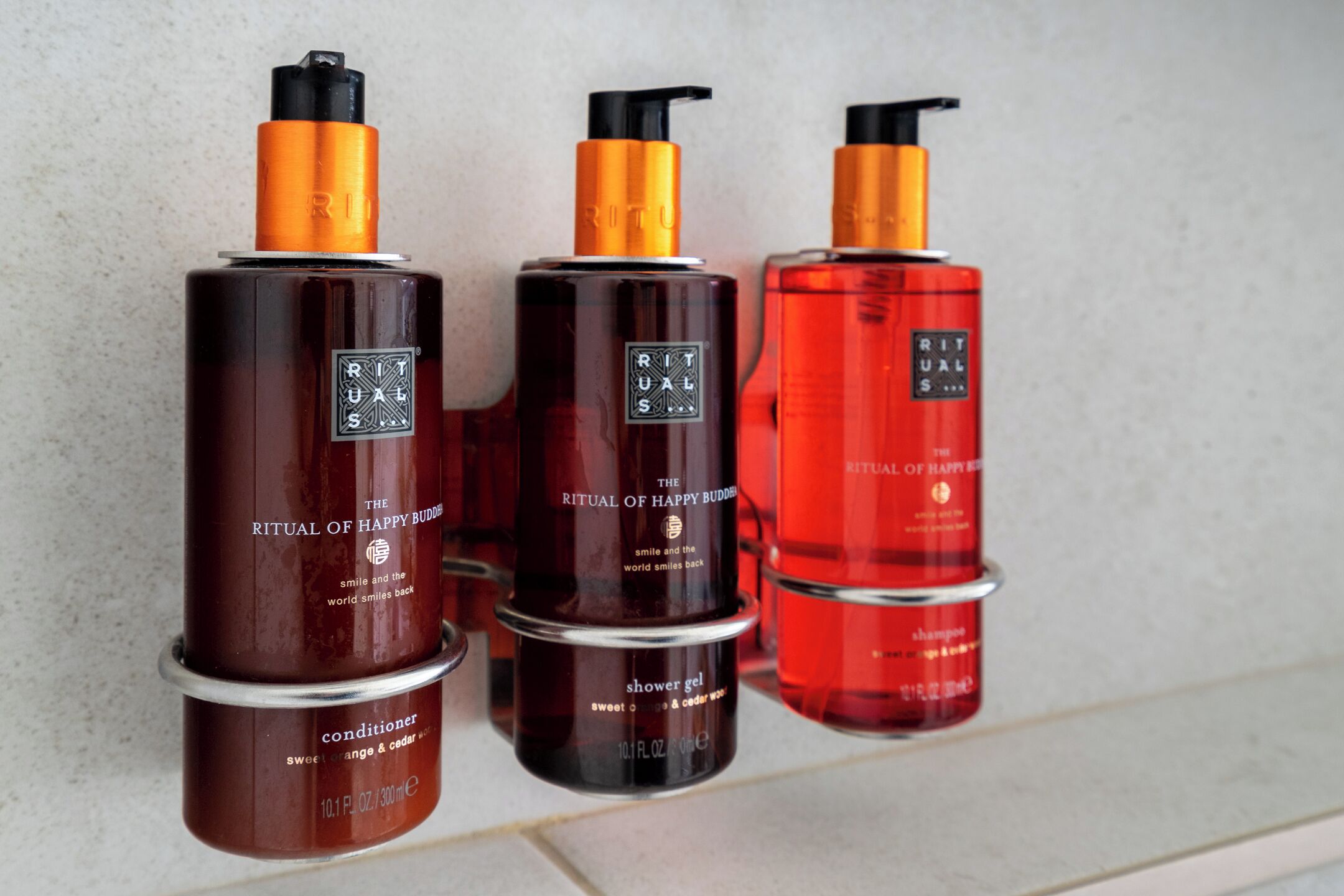 Three bottles of Ritual of Happy Buddies products: conditioner, shower gel, and shampoo.