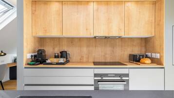 Eine moderne Küche mit Holzschränken, einem Edelstahl-Spülbecken und einem eingebauten Backofen.