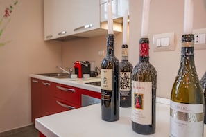 A kitchen with wine bottles on the counter.
