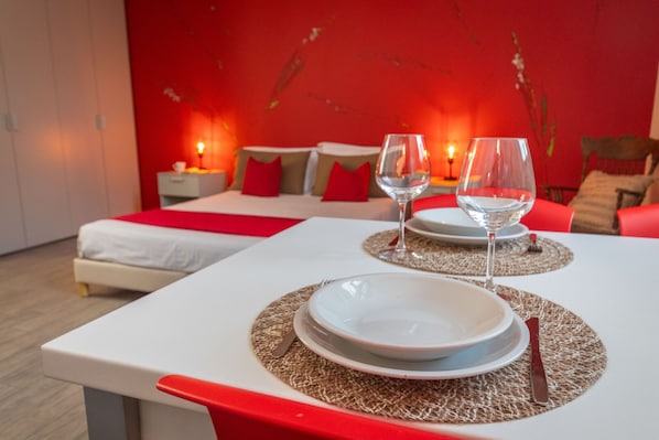 A neatly arranged dining area with a table set for two, including plates, cutlery, and glasses.