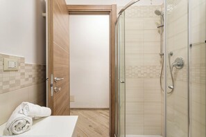 City appartement | Badkamer | Een douche, een haardroger, een bidet, handdoeken