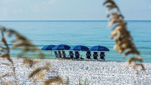 A beach with several blue umbrellas and beach chairs. - Close to 2 Beach Accesses on 30A! Golf Cart, Large Private Pool and Hot Tub (Santa Rosa Beach)