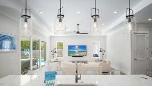 A modern kitchen with a marble countertop, stainless steel sink, and pendant lights. - Close to 2 Beach Accesses on 30A! Golf Cart, Large Private Pool and Hot Tub (Santa Rosa Beach)