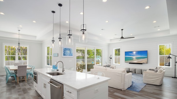 A modern kitchen with white cabinetry, a central island, and pendant lighting. - Close to 2 Beach Accesses on 30A! Golf Cart, Large Private Pool and Hot Tub (Santa Rosa Beach)