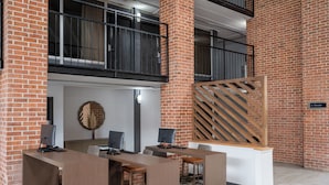 Un espacio de oficina moderno con pared de ladrillo, un escritorio de madera y una computadora.