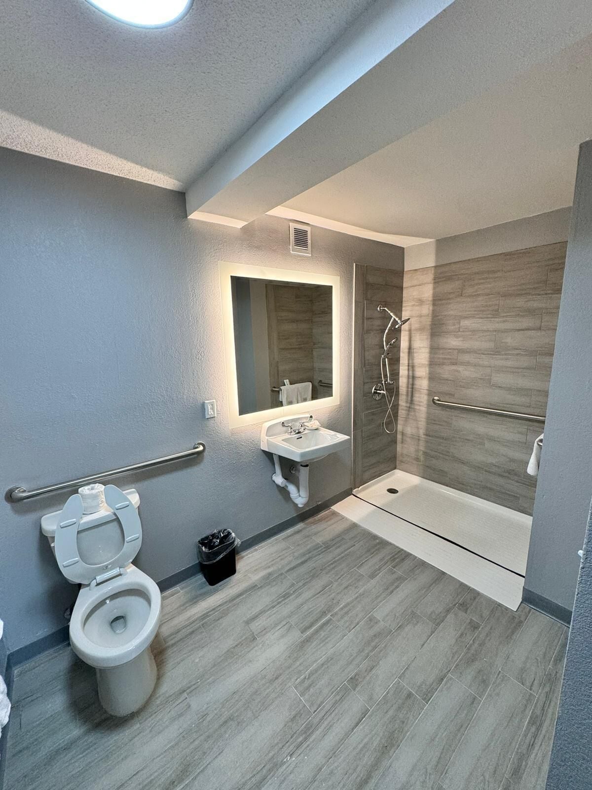 A modern bathroom with a toilet, sink, and shower.