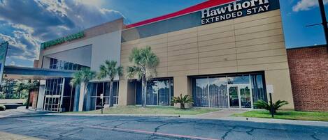 Un hotel Hawthorn Extended Stay con una fachada moderna, ventanas amplias y una entrada ajardinada.