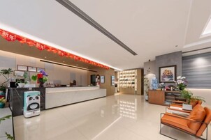 Zona de recepción de un hotel con diseño moderno, un mostrador de recepción, un área de estar y elementos decorativos.