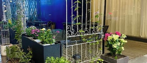 A courtyard with potted plants and a metal fence.