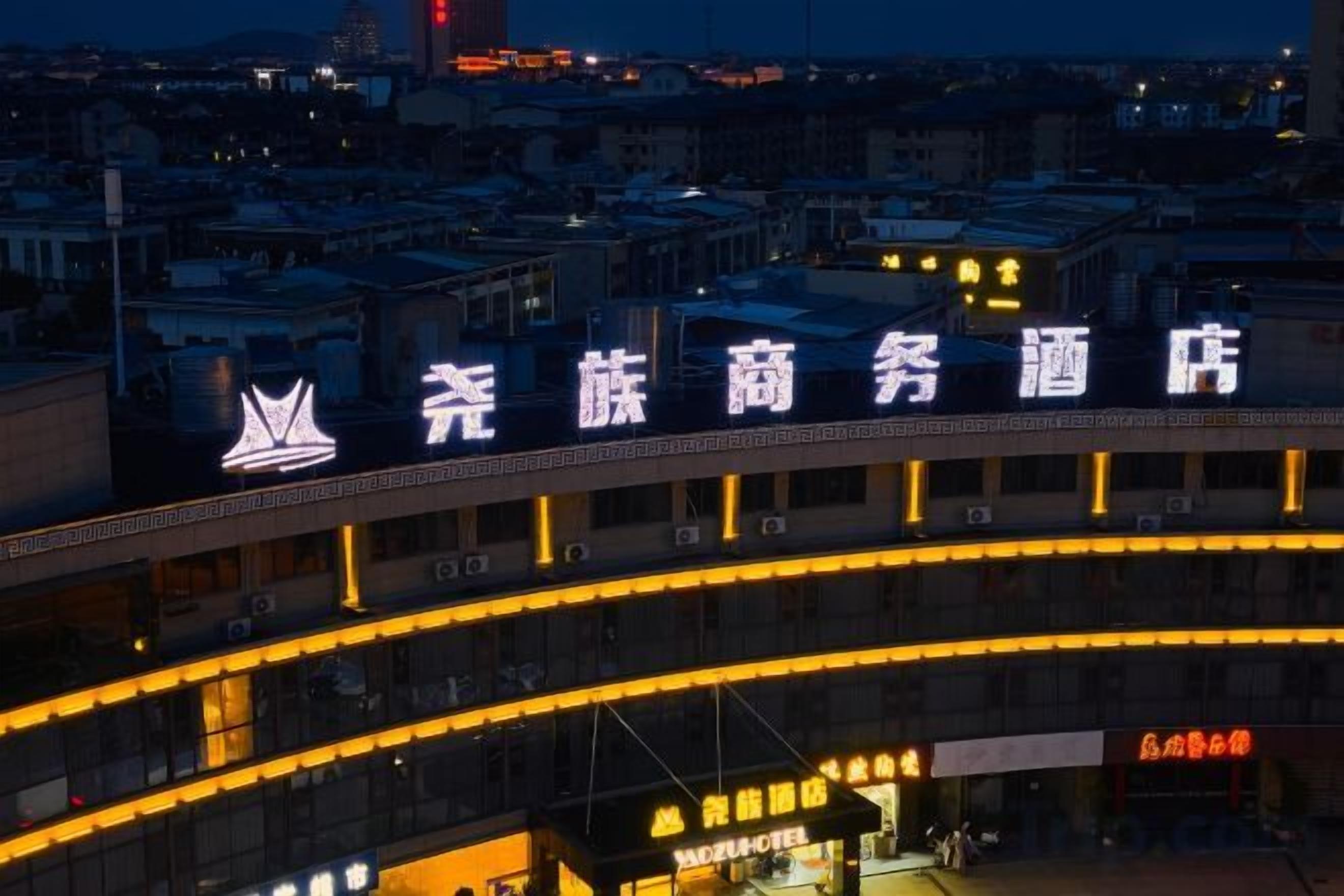 A hotel with a prominent sign in a foreign language, multiple floors, and a cityscape in the background.