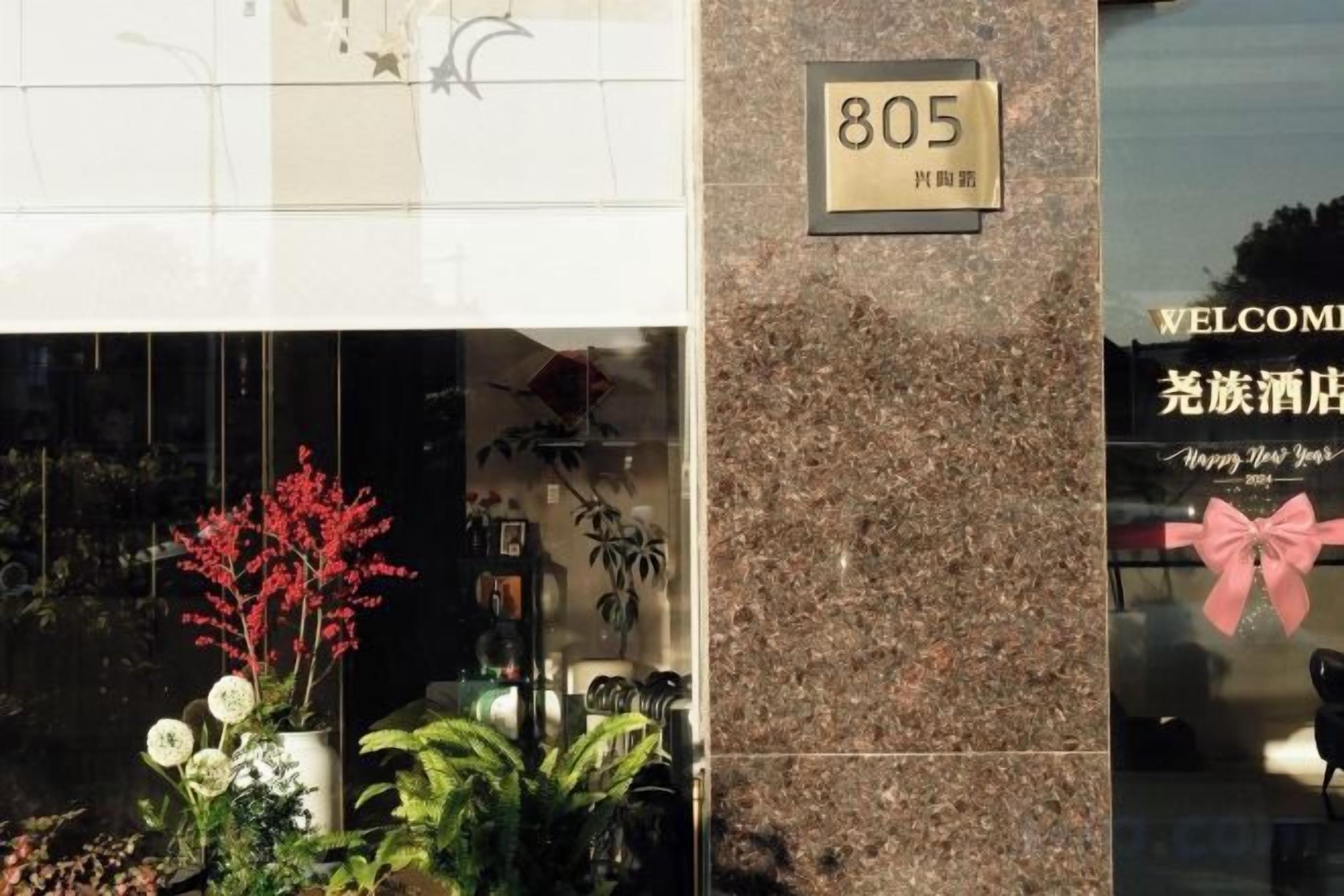 A building entrance with a sign reading '805' and a welcome sign with a bow.