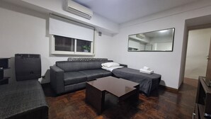 A modern living room with a grey sofa, a wooden coffee table, a small TV, and a window with blinds. - Hornera Rodi - Strategic location, parking, and pool (Rosario)