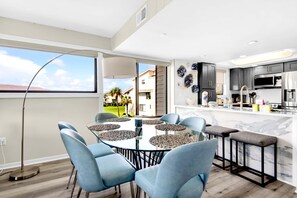 Enjoy meals in the kitchen with a central island and dining area featuring a round table and comfortable seating.