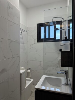 Een douche, handdoeken, toiletpapier