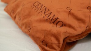 A bed with a pillow featuring the text "CENNAMO" and a yellow headboard. - Ischia Mare (Forio)