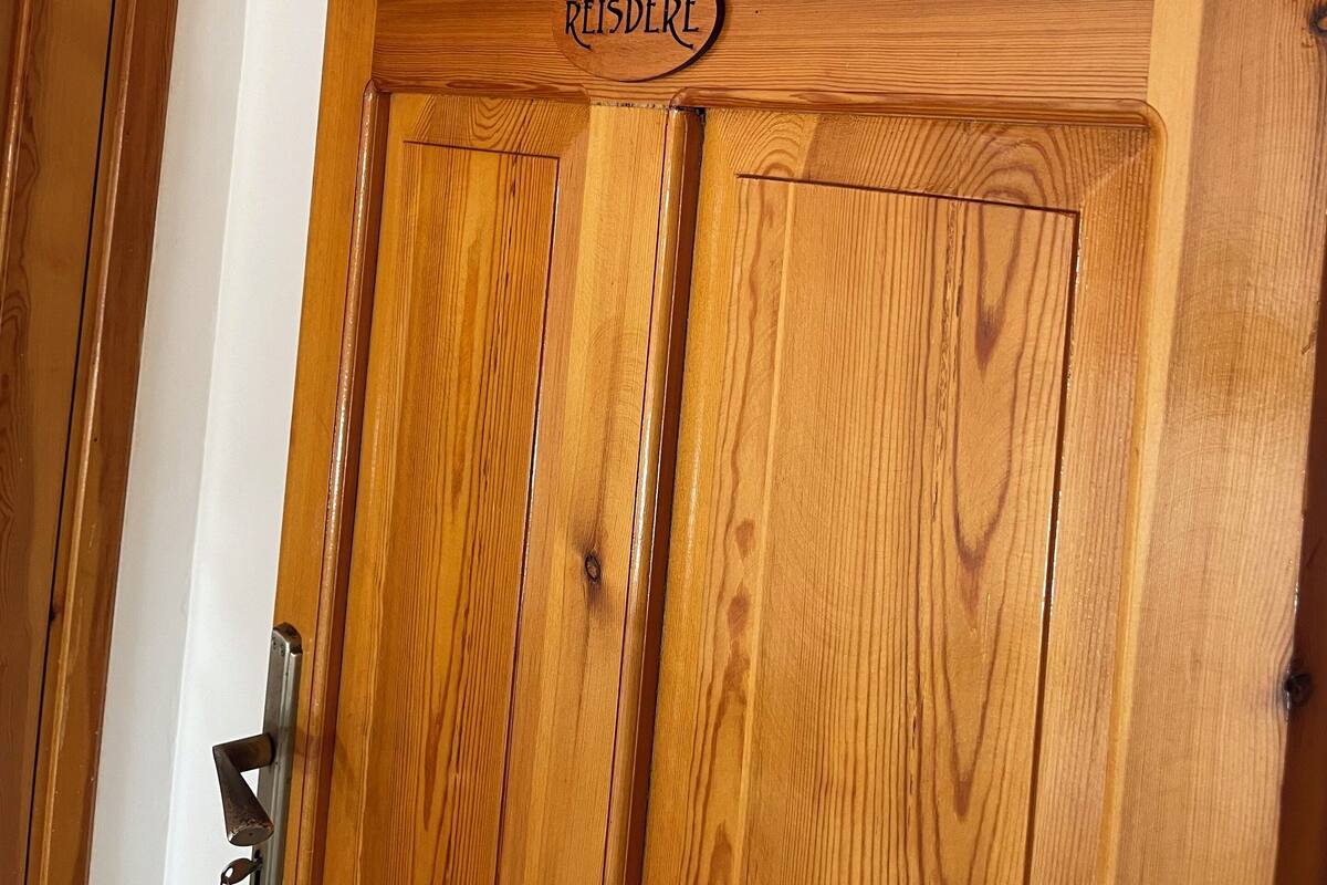 A wooden door with a sign that reads "REISDERE".