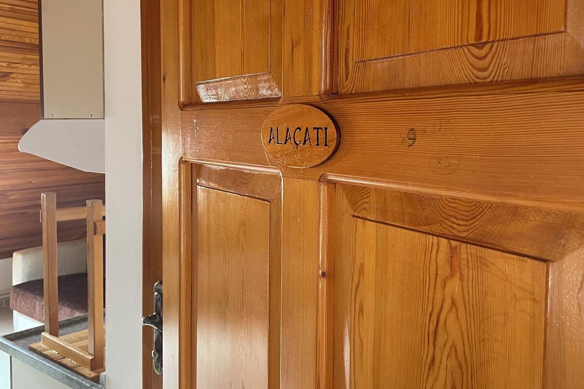 A wooden door with a nameplate reading "ALACATI".
