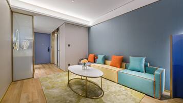 A modern living room with a sofa, a coffee table, and a glass door leading to another room.