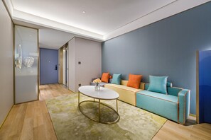 Un salon moderne avec un canapé, une table basse et une porte vitrée donnant sur une autre pièce.