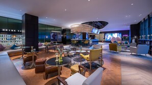 Eine moderne Lounge mit Bar, Sitzgelegenheiten und einer Auswahl an Spirituosenflaschen.