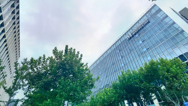 A modern building with a glass facade and a sign that reads "The London." - Manxin Hotel Shanghai Hongqiao Airport Internation (Shanghai)