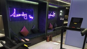 A gym with a treadmill, stationary bike, and a neon sign reading "Laundry". - Manxin Hotel Shanghai Hongqiao Airport Internation (Shanghai)