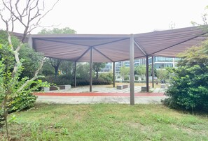 A covered outdoor area with a modern design, featuring a metal framework and a red pathway. - Manxin Hotel Shanghai Hongqiao Airport Internation (Shanghai)