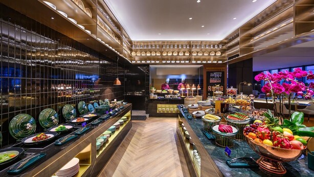 A buffet area with various food items and a chef preparing food in the background. - Manxin Hotel Shanghai Hongqiao Airport Internation (Shanghai)