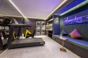 A modern gym with a treadmill, stationary bike, and wall-mounted exercise equipment. - Manxin Hotel Shanghai Hongqiao Airport Internation (Shanghai)