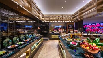 A buffet area with a variety of dishes and a chef preparing food.