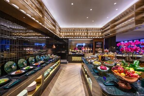 Un'area buffet con una varietà di piatti e uno chef che cucina.