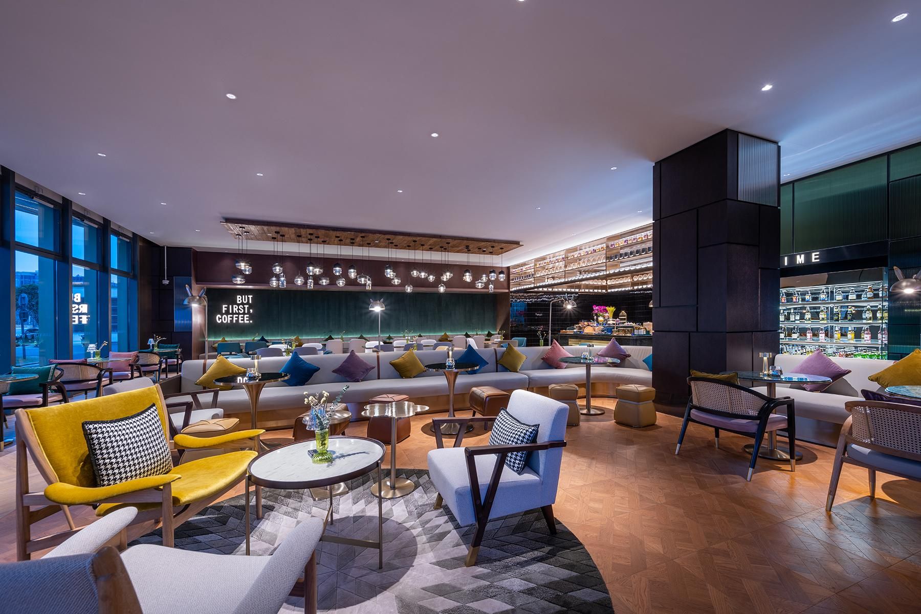 Ein stilvoller Aufenthaltsbereich mit Sofas, Sesseln und einer Bar mit Flaschenregalen.