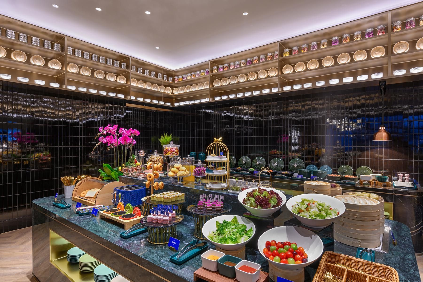 A buffet area with various food items and a display of glass jars on shelves.