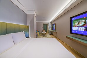 Une chambre d’hôtel comprenant un lit, une télévision et un bureau avec une chaise.