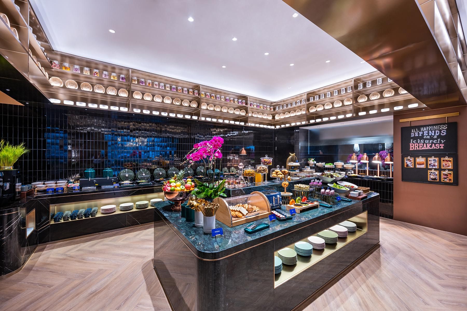 A modern breakfast buffet with a variety of food items and a decorative orchid centerpiece.