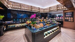 Ein modernes Frühstücksbuffet mit verschiedenen Speisen und einer dekorativen Orchideen-Zentralstück.