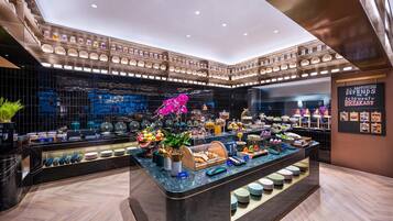 A modern breakfast buffet with a variety of food items and a decorative orchid centerpiece.