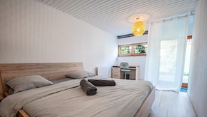Une chambre à coucher avec un lit en bois, un bureau et une chaise.