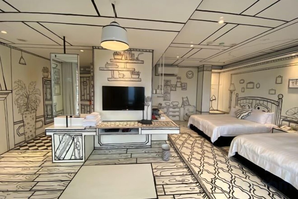 A hotel room with a large bed, a desk with a flat-screen TV, and a patterned floor.