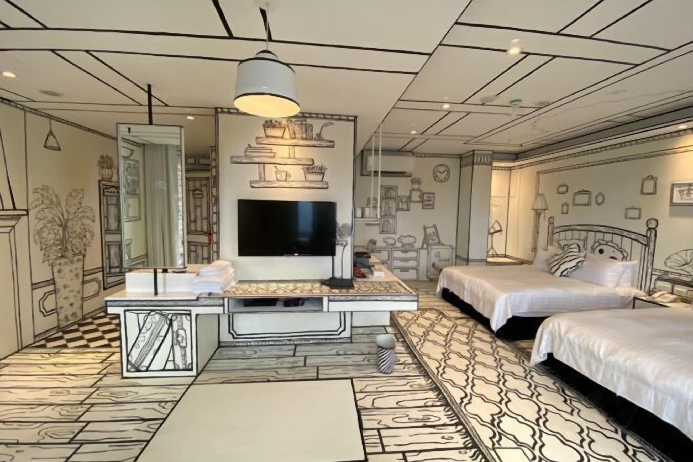 A bedroom with a large bed, a TV, and a desk.