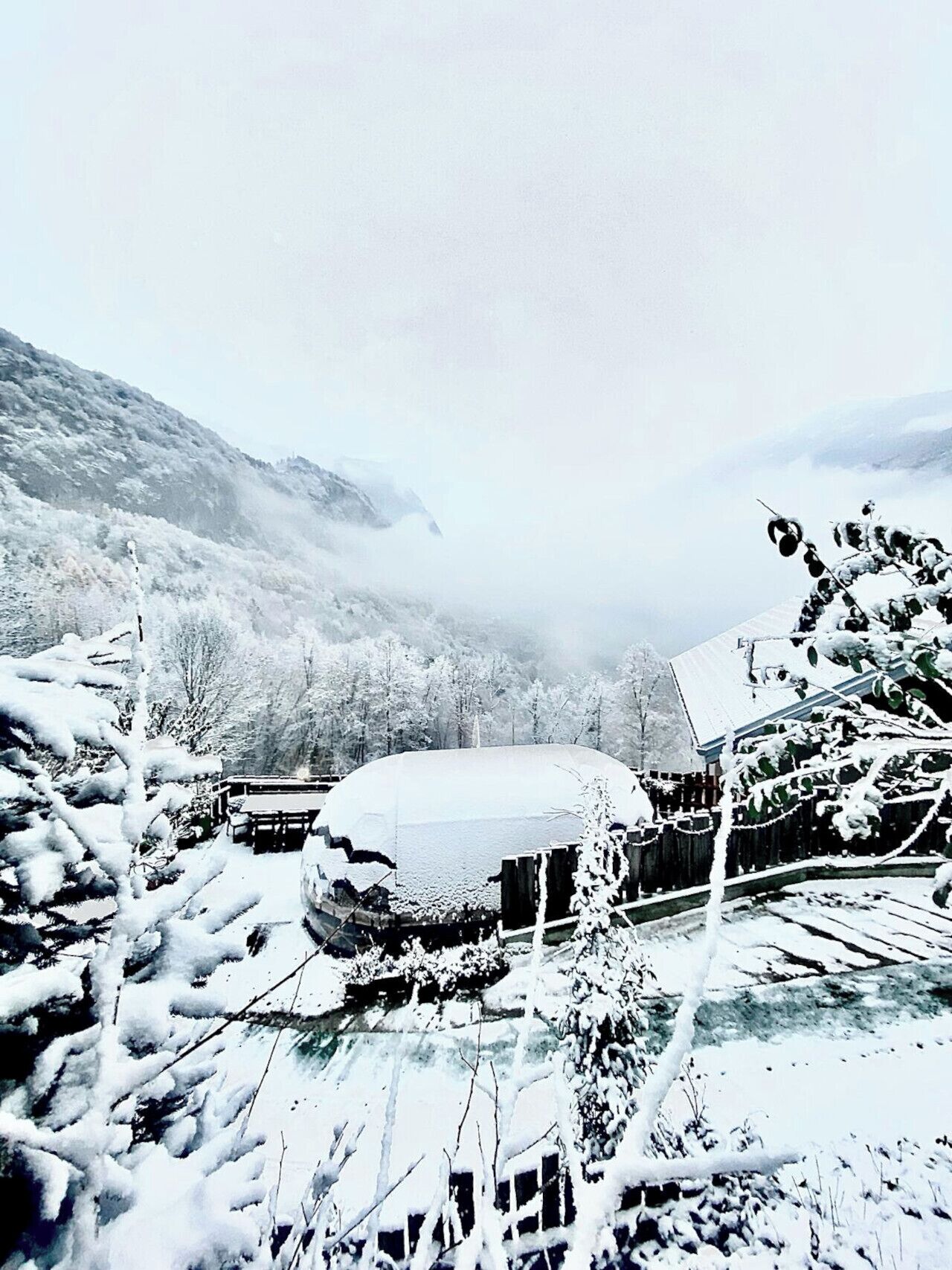 Un paysage enneigé, avec un bâtiment partiellement recouvert de neige.