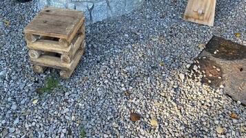 Un hogar de piedra con un banco de madera y una pequeña mesa cerca.